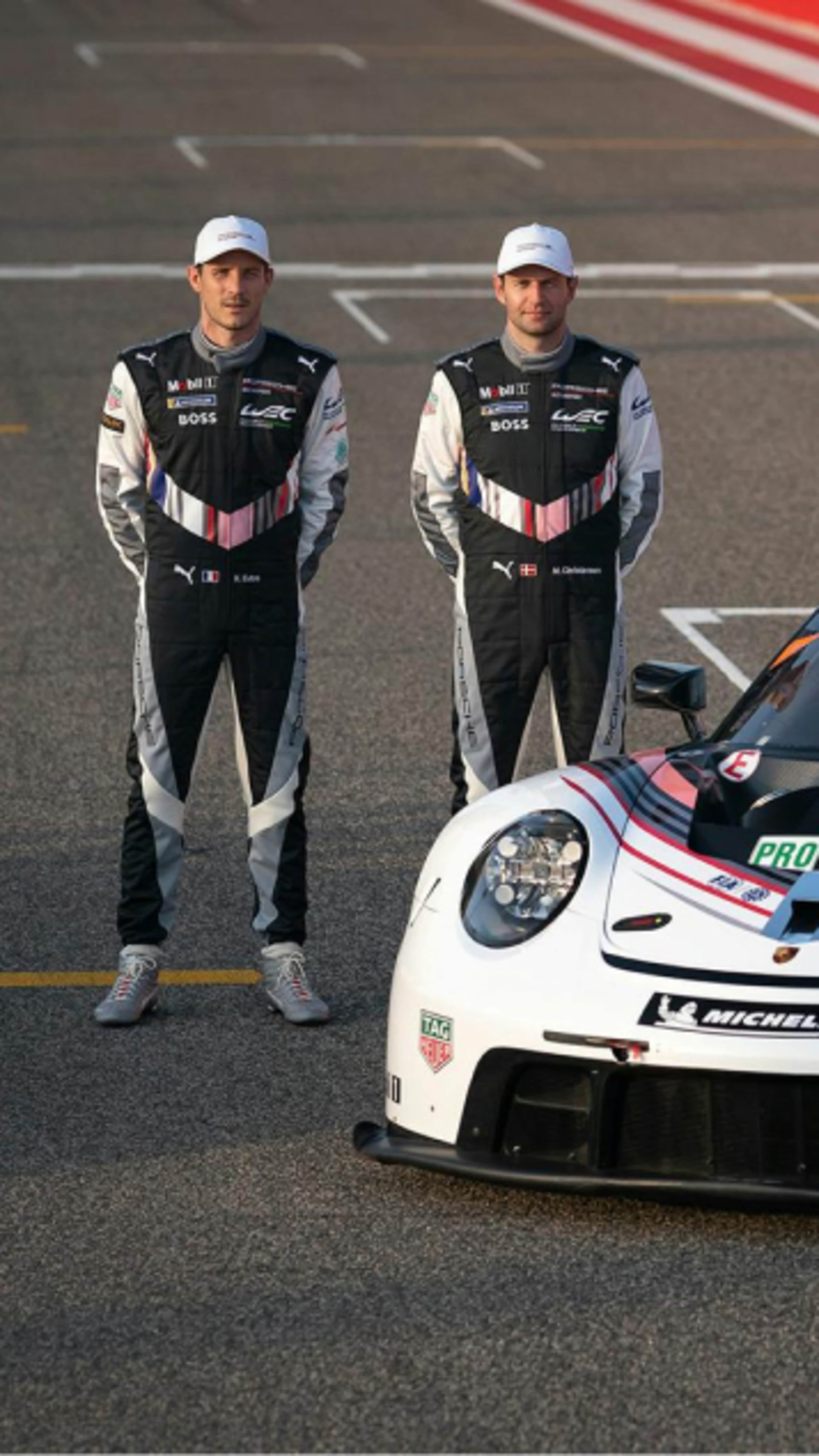 Two drivers standing next to Porsche car on the track